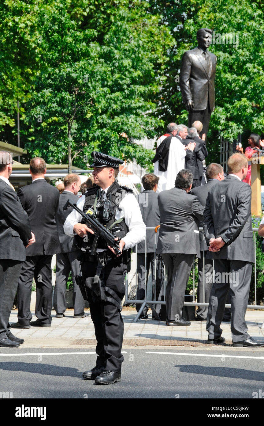 Agente di polizia armato alla cerimonia di inaugurazione del Presidente Ronald Reagan statua in bronzo all ambasciata americana Grosvenor Square London street scene UK Foto Stock