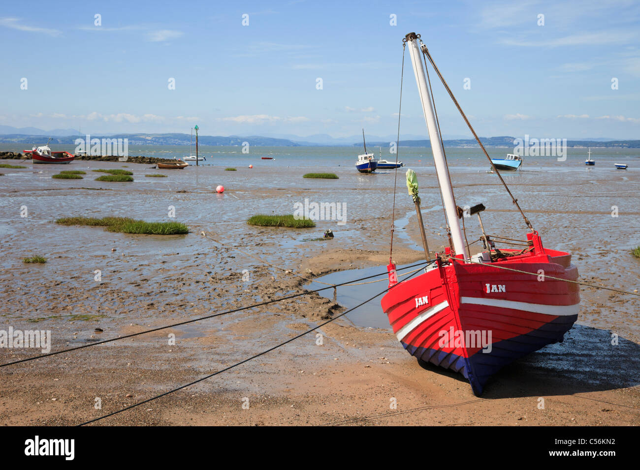 Spiaggiata rosso barca sulle sabbie a bassa marea a Morecambe Bay, Lancashire, Inghilterra, Regno Unito, Gran Bretagna. Foto Stock