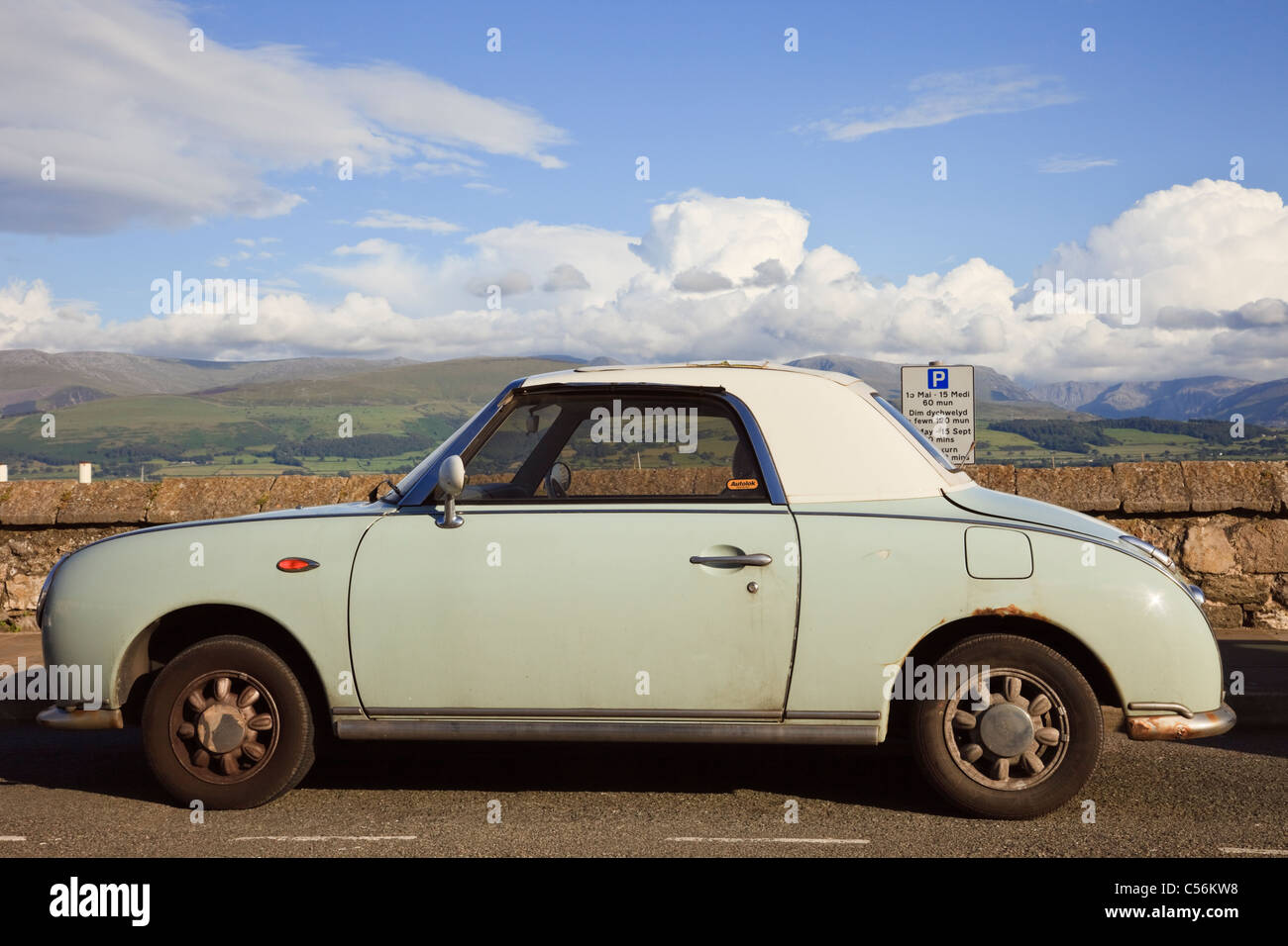 Verde in stile retrò Nissan Figaro automatic soft top sport coupe auto parcheggiate sul lungomare. Anglesey, Galles del Nord, Regno Unito, Gran Bretagna. Foto Stock