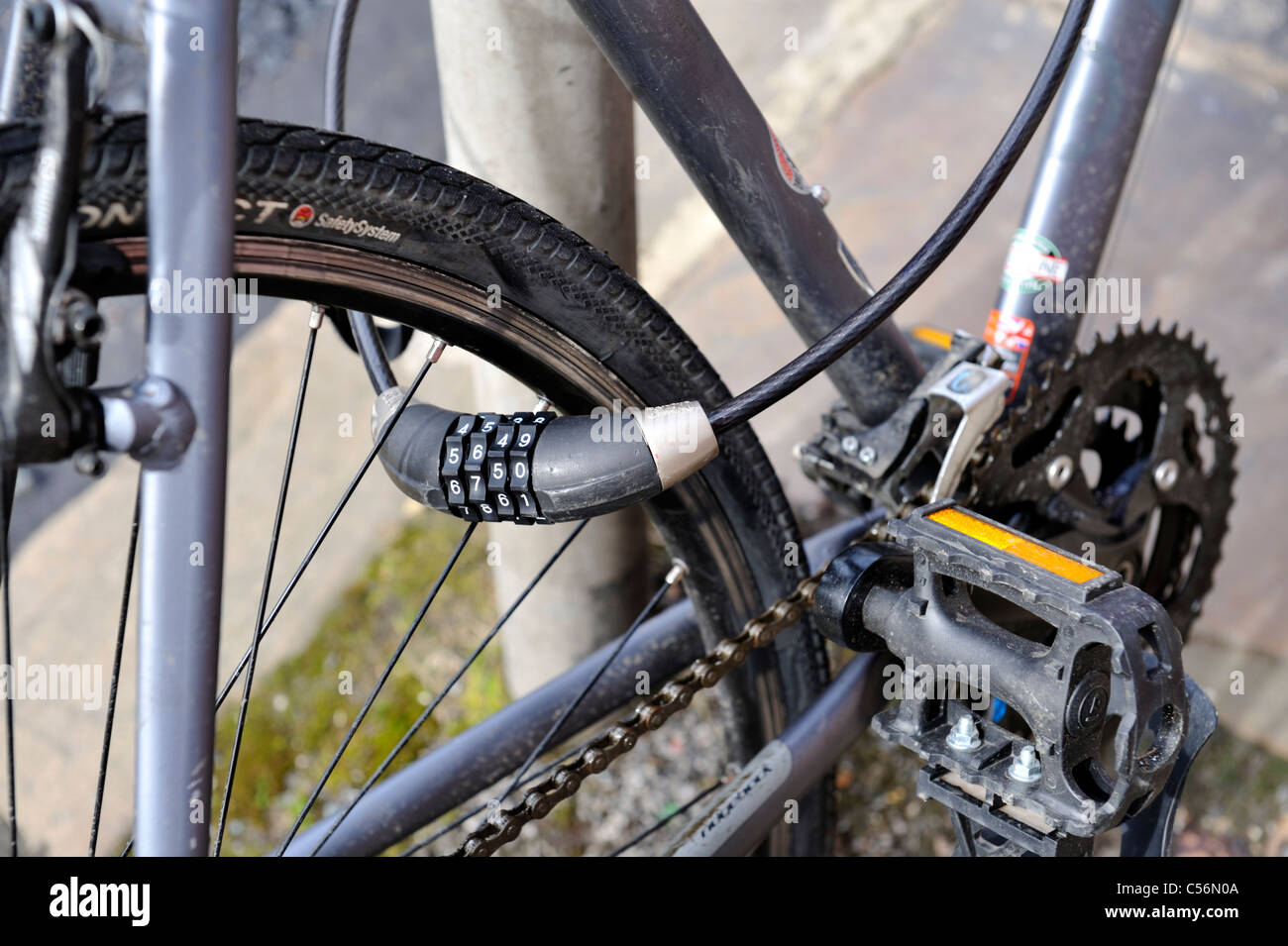Bicicletta con la combinazione di blocco di sicurezza incatenato al post Foto Stock