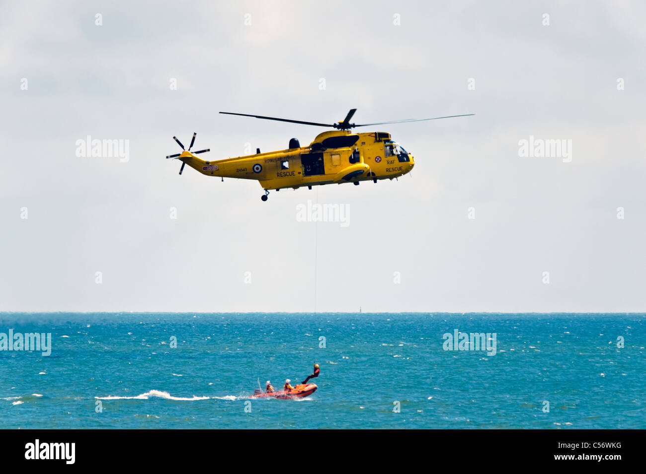 Ricerca e salvataggio Sea King e elicottero RNLI scialuppe di salvataggio in mare, National Air show, Swansea, Wales, Regno Unito. Winchman prelevati. Foto Stock