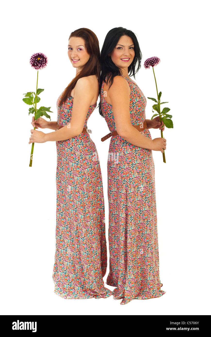 Lunghezza completa di due belle donne nella stessa azienda vestito fiori isolati su sfondo bianco Foto Stock