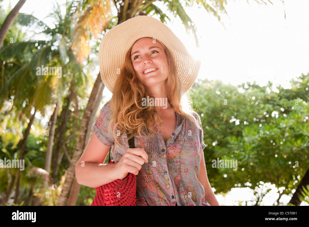 Donna che indossa cappello in resort tropicale Foto Stock