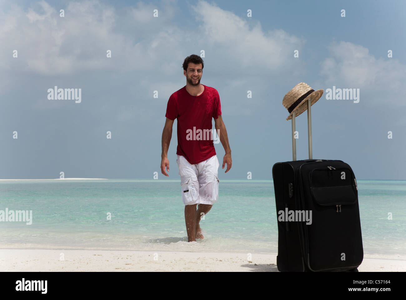 L'uomo con la valigia sulla spiaggia Foto stock - Alamy