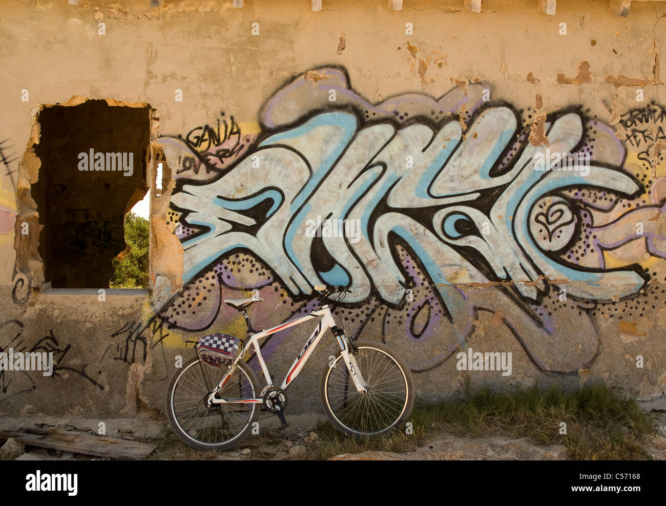 Mountain bike a sinistra al di fuori di un graffiti edificio abbandonato. Foto Stock