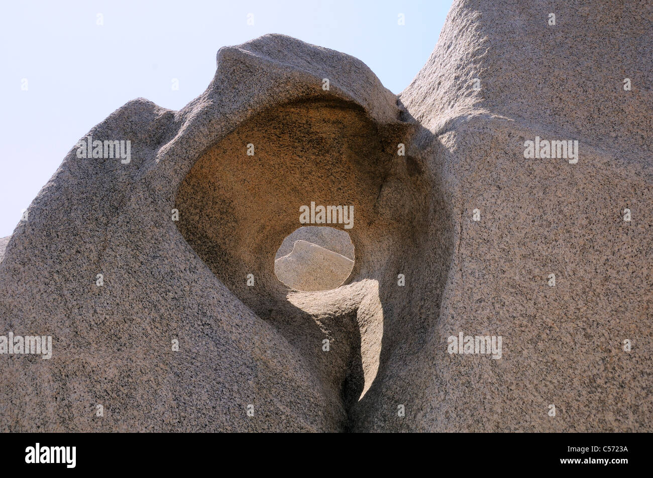 'Oblò' finestra intagliata attraverso le rocce di granito dal vento, meteo e di erosione del mare, Punto di Campomoro, Corsica, Francia. Foto Stock
