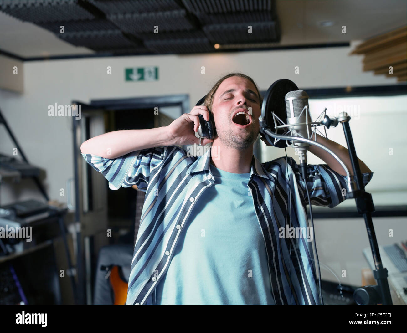 Uomo a cantare in studio di registrazione Foto Stock