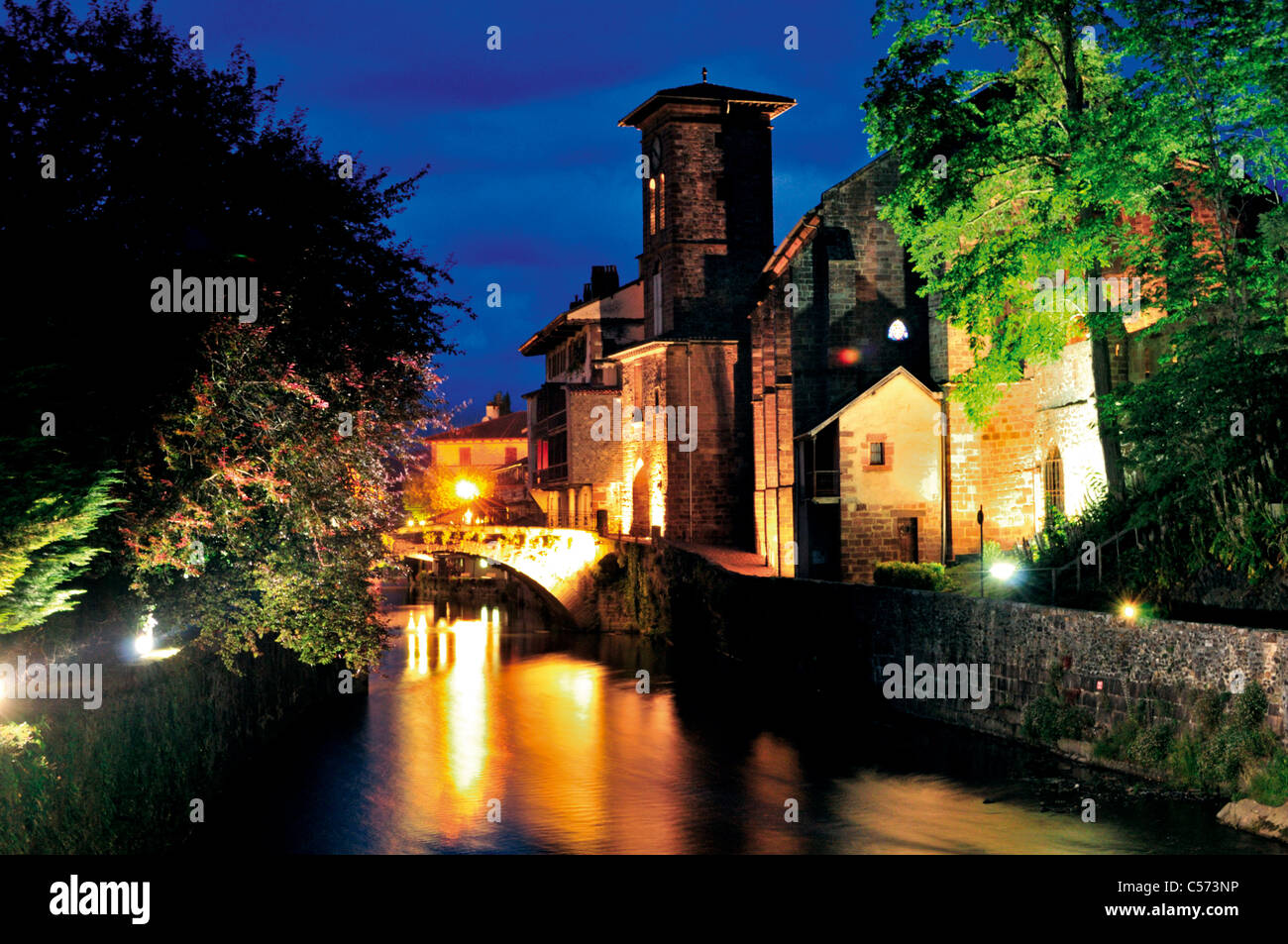 Francia, St. James modo: vista notturna del fiume Nive e chiesa parrocchiale Notre Dame a San Jean-Pied-de-Port Foto Stock