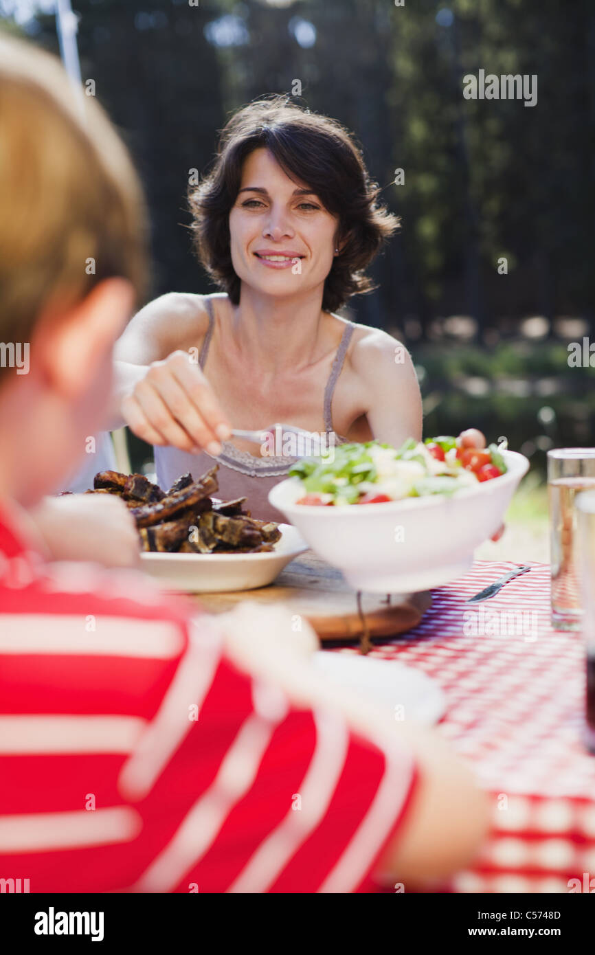 Madre che serve insalate a picnic Foto Stock