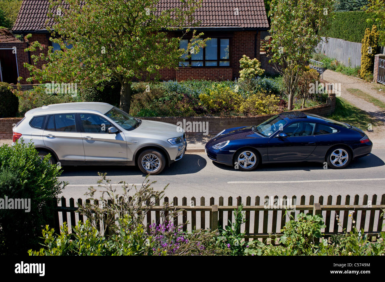 Tedesco di lusso auto parcheggiate nel villaggio inglese street Foto Stock