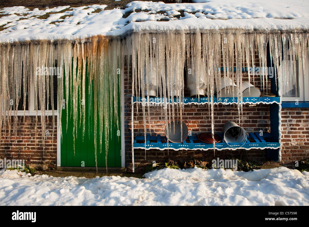 I Paesi Bassi, Staphorst, inverno, ghiaccioli sul tetto di fattoria. Foto Stock