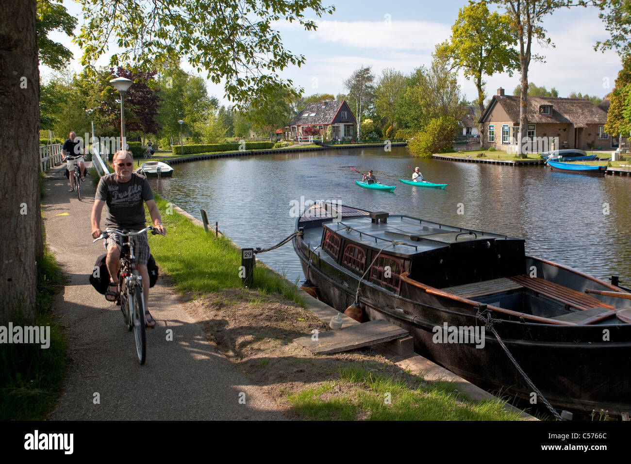 I Paesi Bassi, Giethoorn, villaggio con quasi solo le vie navigabili. Turisti che si godono il kayak ride e ciclisti. Foto Stock