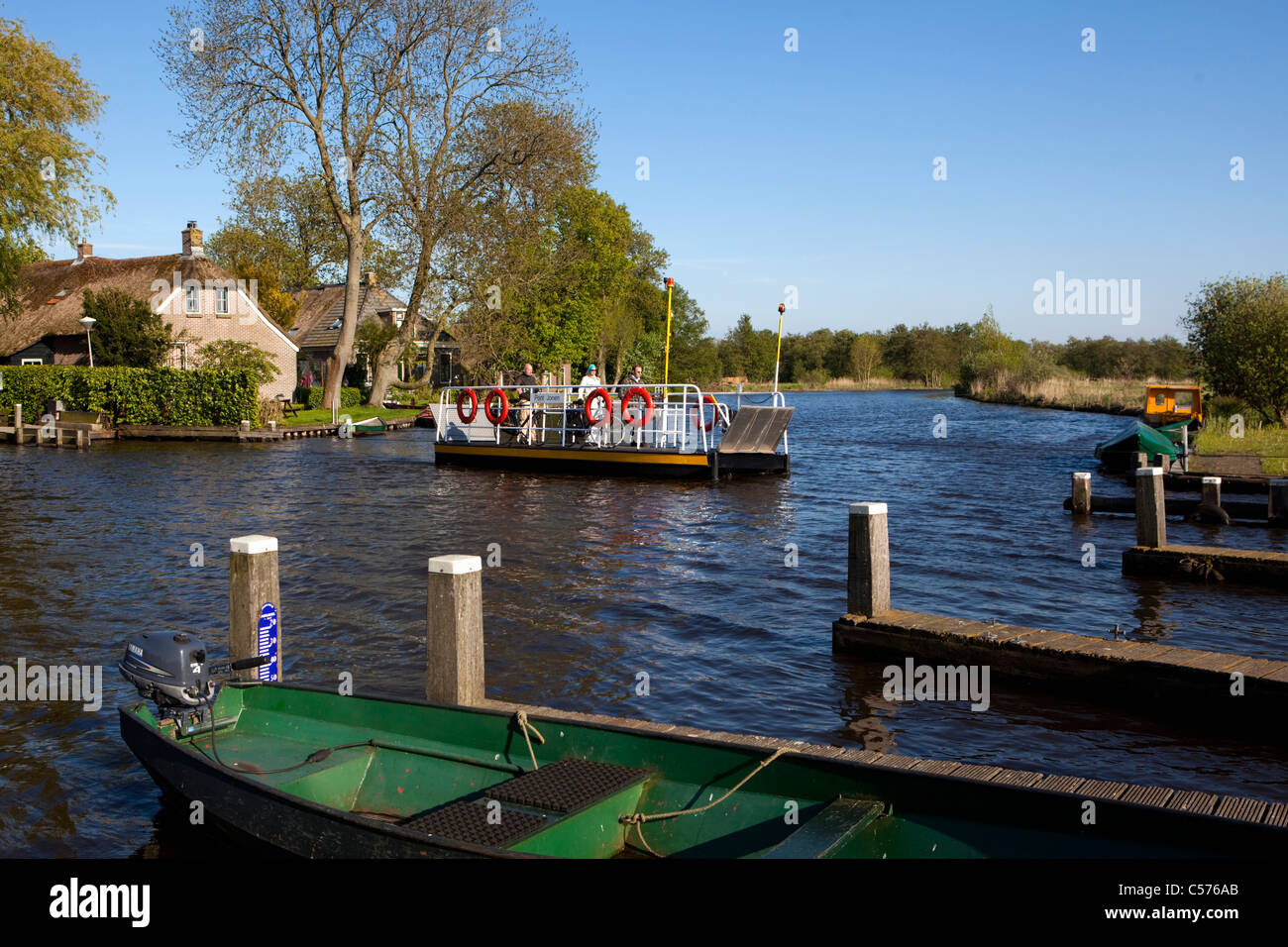 I Paesi Bassi, Jonen, villaggio con quasi solo le vie navigabili. I turisti con biciclette sul piccolo traghetto. Foto Stock