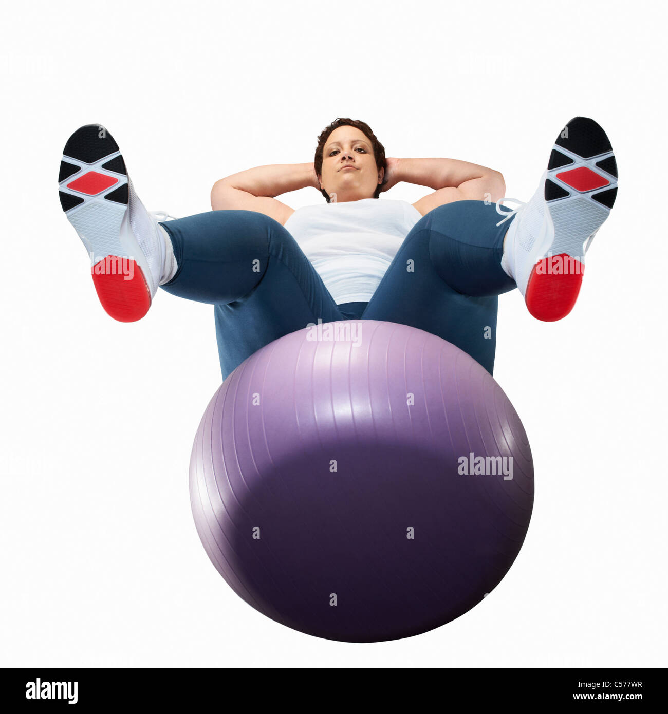 Donna di grandi dimensioni utilizzando palla ginnica Foto Stock