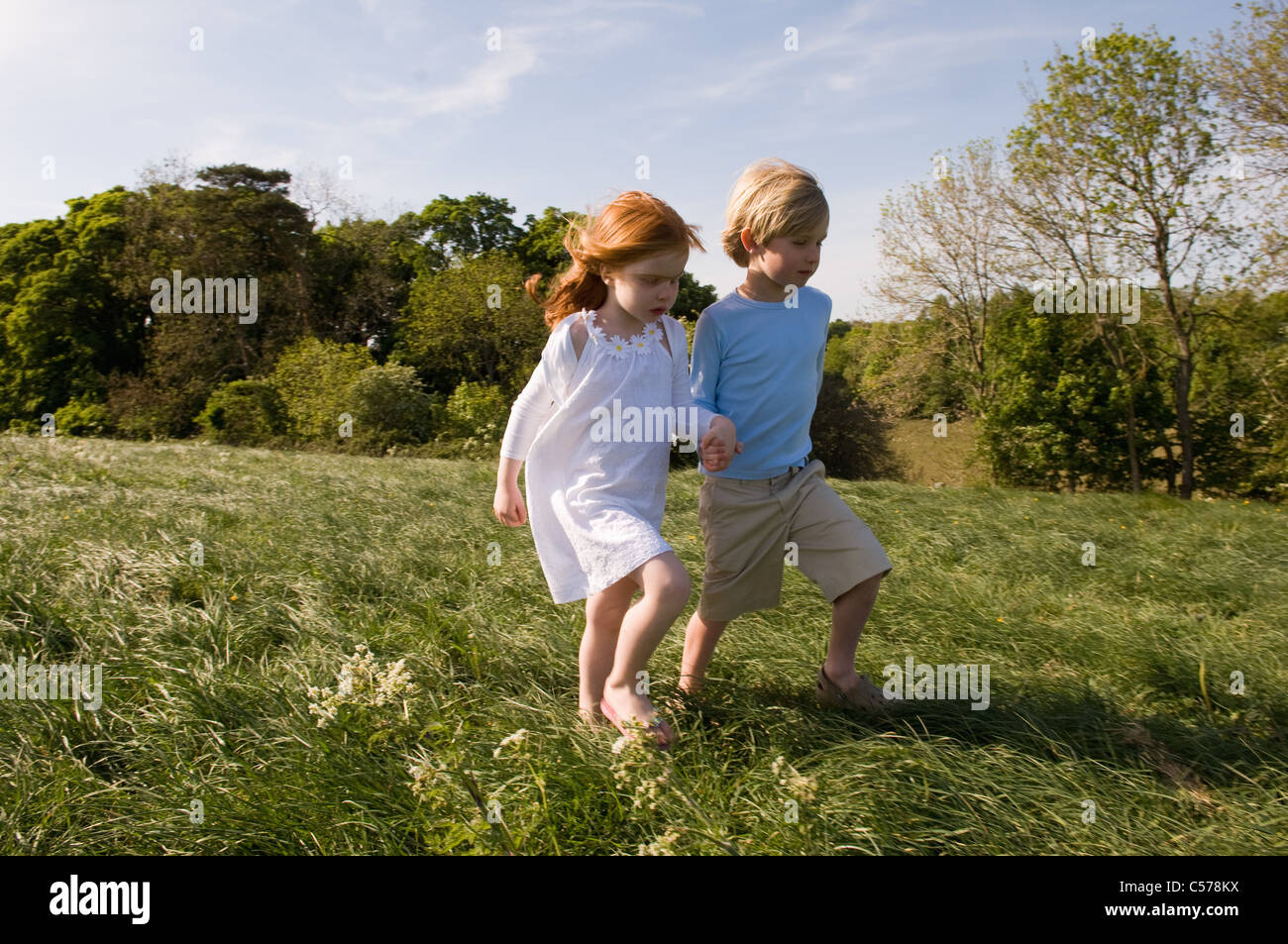 I bambini si tengono per mano nel campo Foto Stock