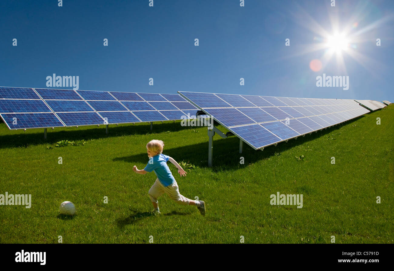 Ragazzo giocando in campo da pannelli solari Foto Stock
