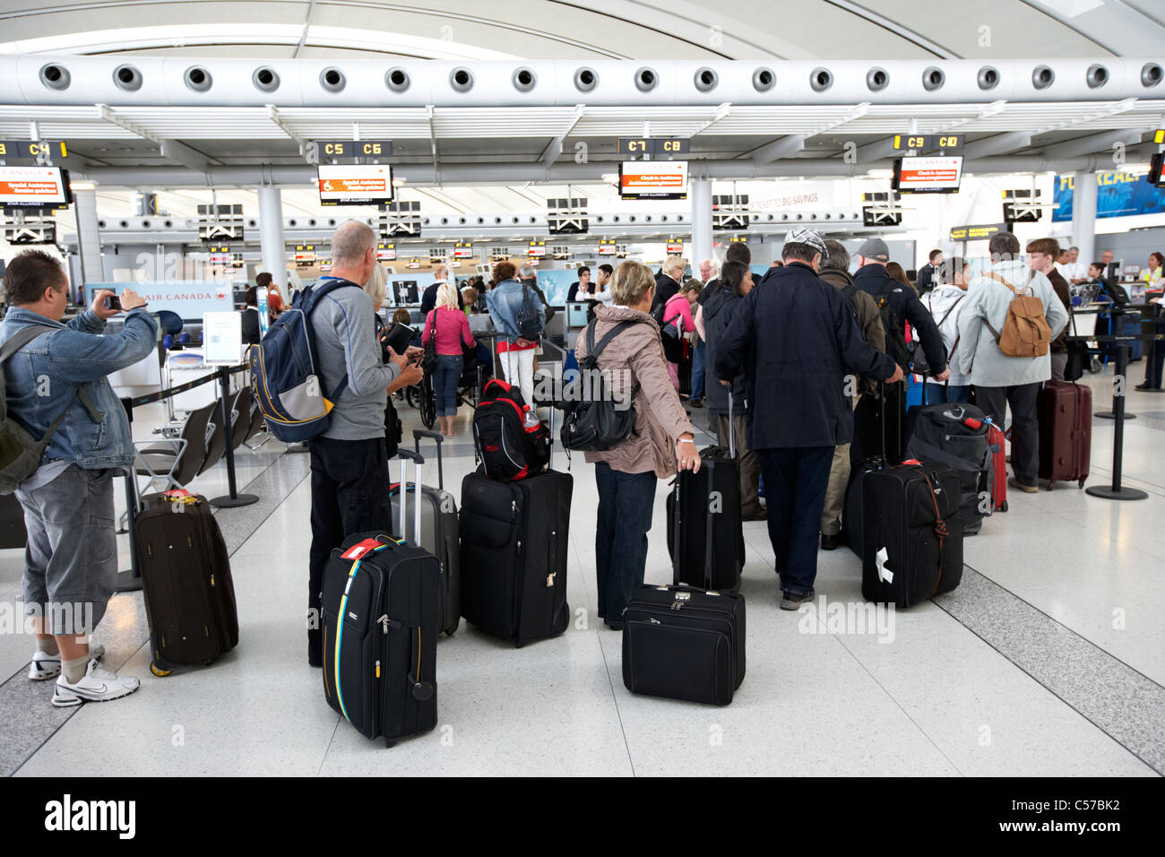 Accodamento dei passeggeri presso i banchi check-in all'Aeroporto Internazionale Pearson di Toronto Ontario Canada Foto Stock