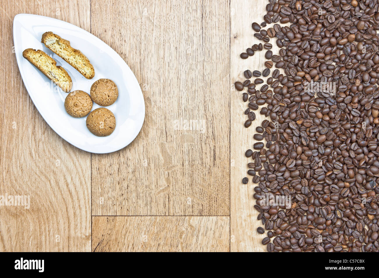I chicchi di caffè sul piatto di legno con i cookie su un bianco Foto Stock