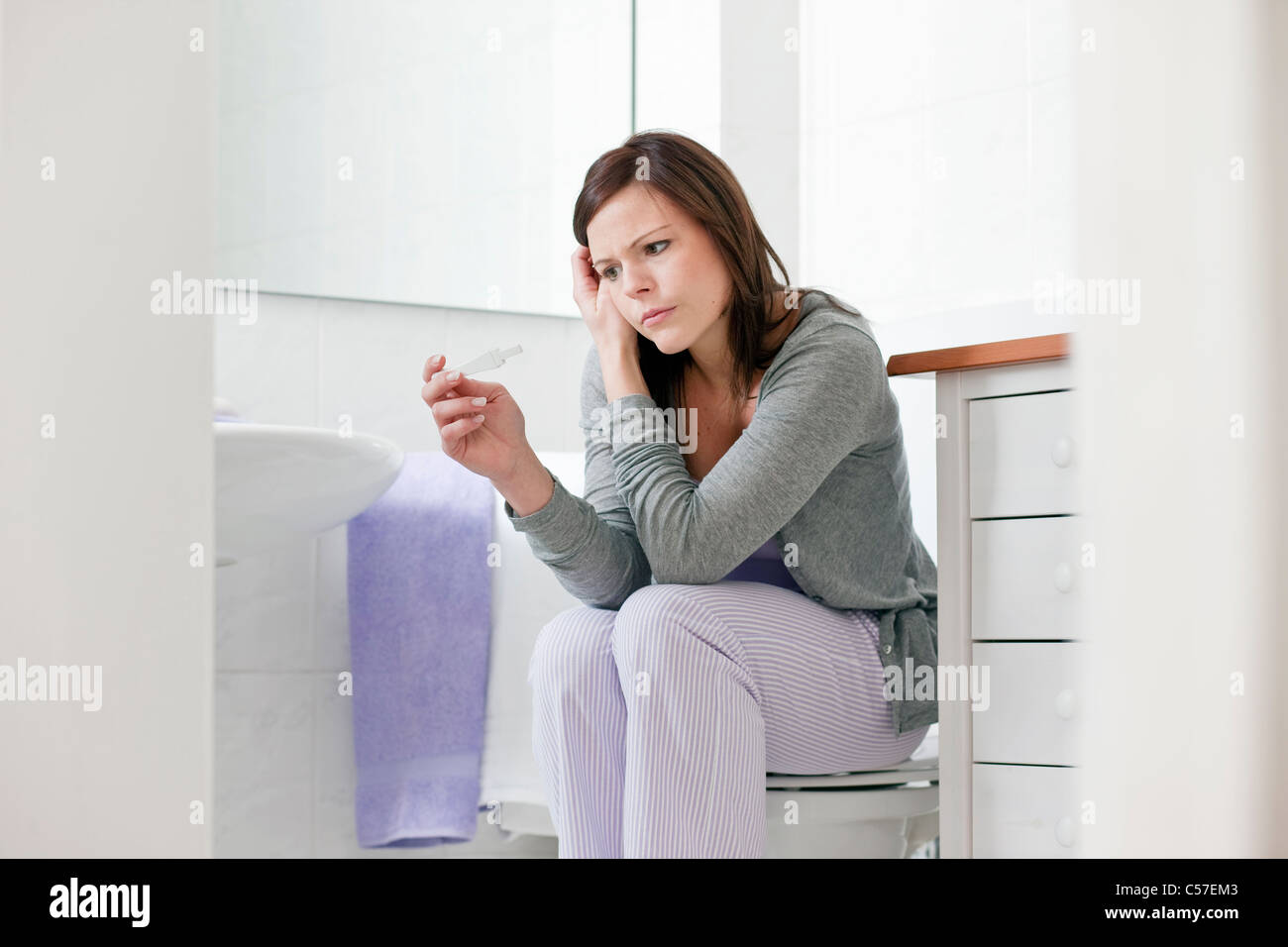 La donna in questione tenendo al test di gravidanza Foto Stock