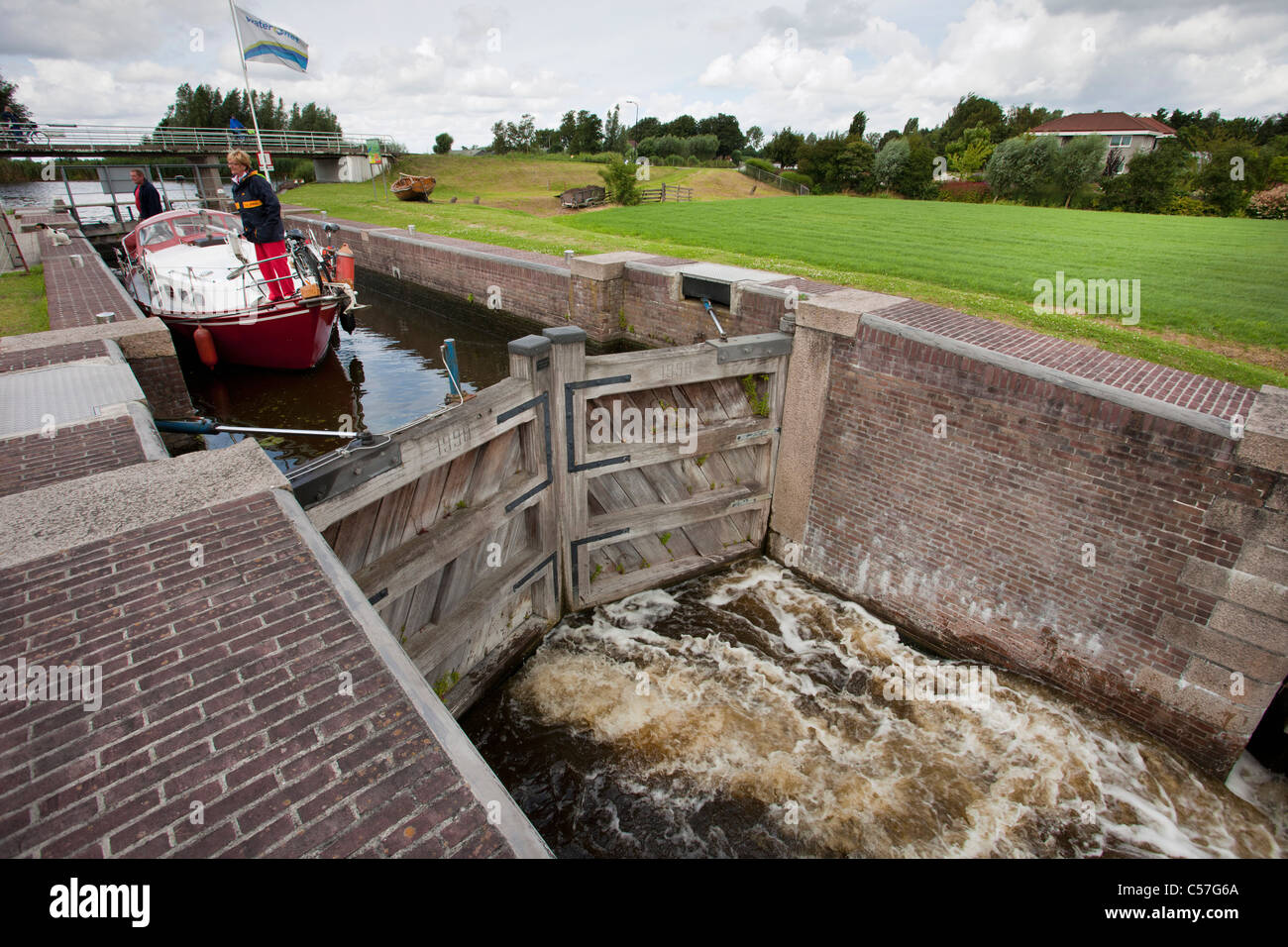 Nei Paesi Bassi, vicino Bodegraven, Meije fiume. Piacere yacht in attesa nella serratura. Foto Stock