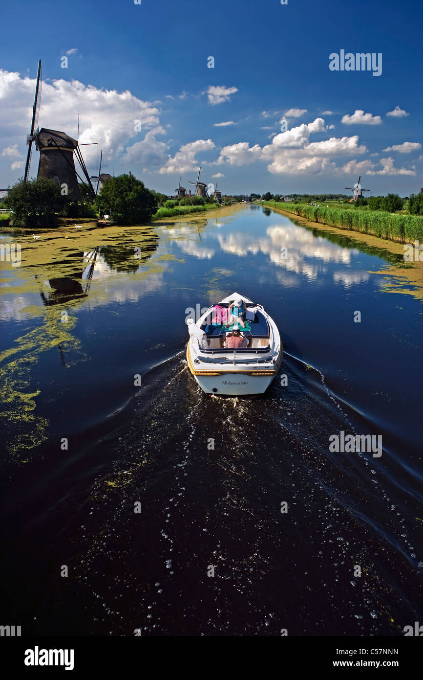 I Paesi Bassi, Kinderdijk vicino a Rotterdam. Mulini a vento in polder. Unesco - Sito Patrimonio dell'umanità. Giovane e cane in barca. Foto Stock