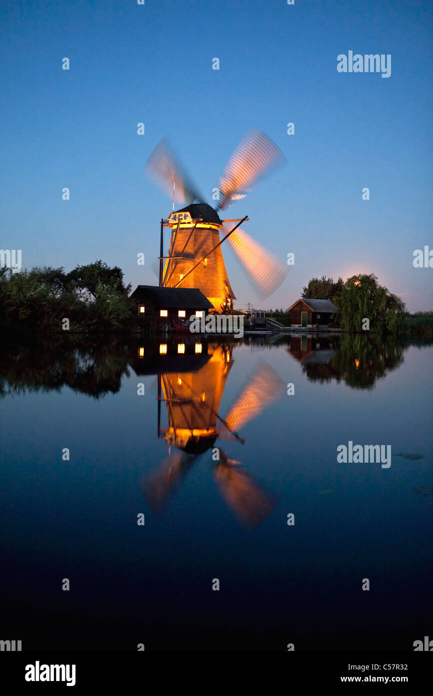 I Paesi Bassi, Kinderdijk, illuminato il mulino a vento, Sito Patrimonio Mondiale dell'Unesco. Foto Stock
