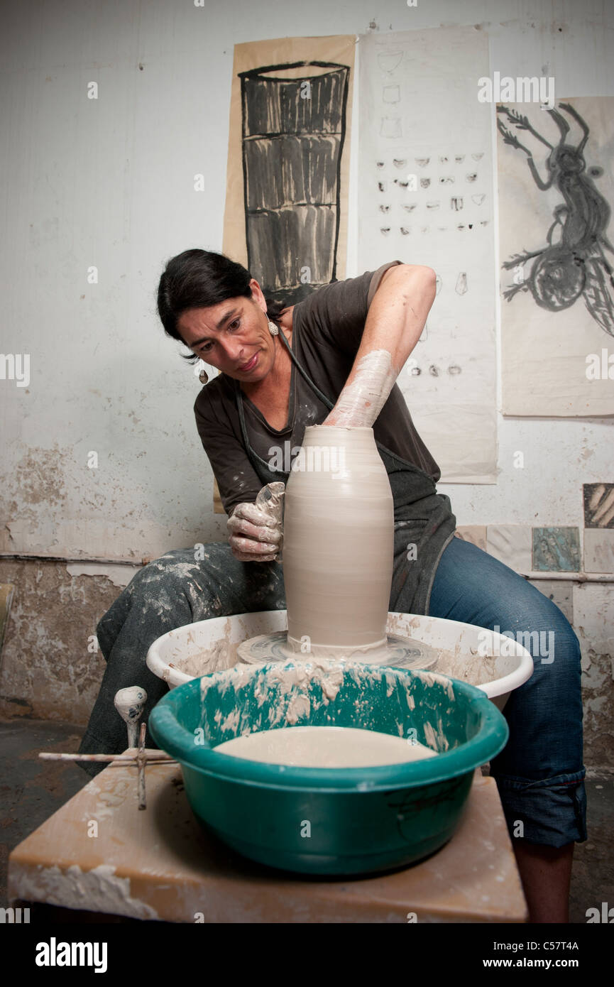 Ceramista femmina usando un tornio del vasaio al lavoro su un