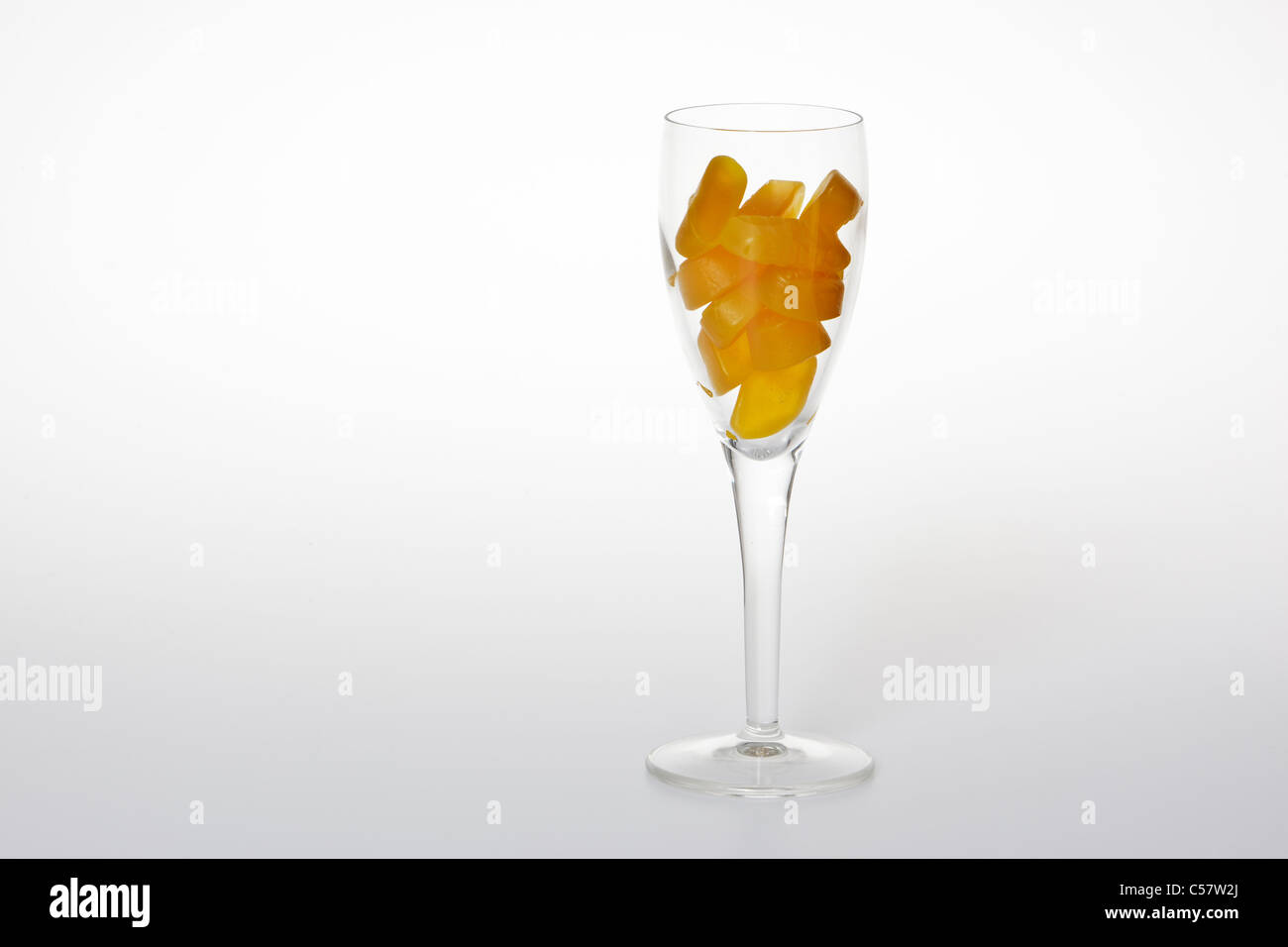 Il vino di vetro riempita con il vino giallo gengive contro uno sfondo bianco Foto Stock