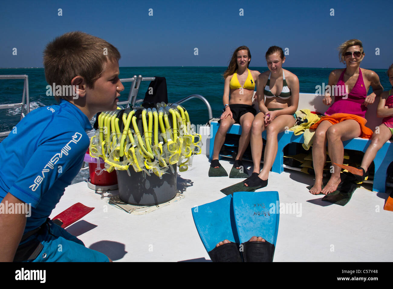Le persone interagiscono con i trigoni a Stingray City, Isole Cayman Foto Stock