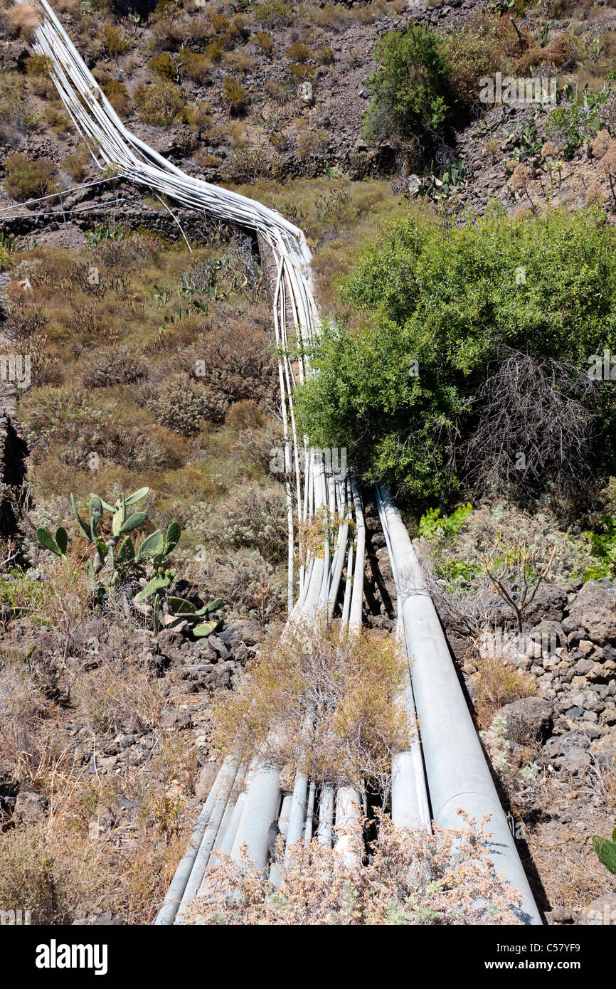 Acqua tubi che trasportano acqua di irrigazione eroga attraverso un barranco in Guia de Isora zona di Tenerife Isole Canarie Spagna Foto Stock