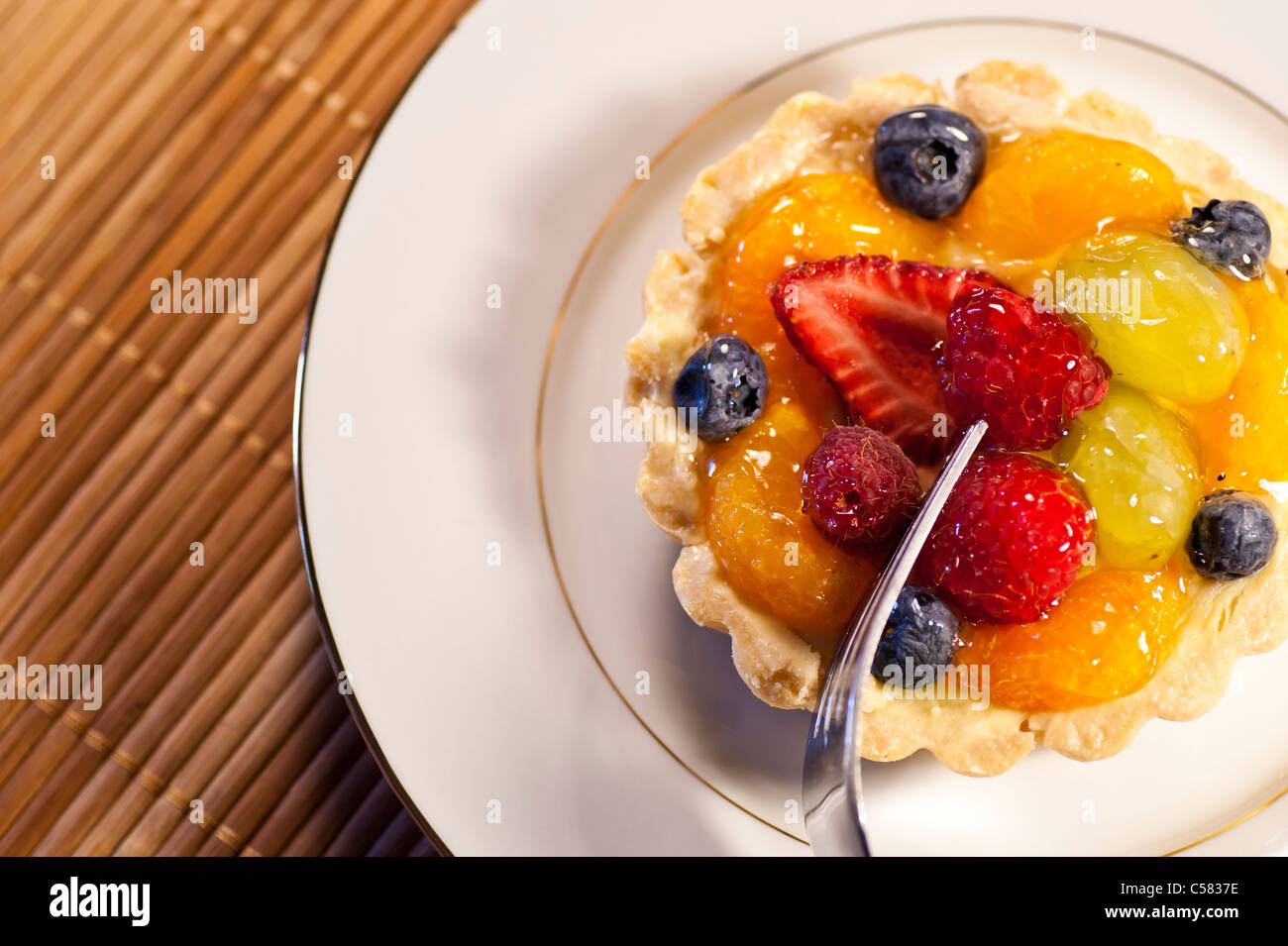 Guardando verso il basso su una golosa crema pasticcera crostata di frutta. Foto Stock