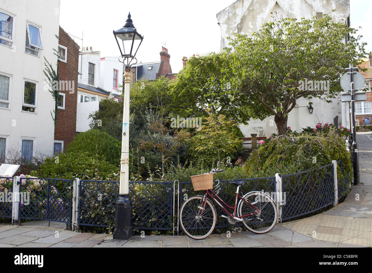 Bicicletta e piccolo parco e lampada posta pittoresco street view in Hastings Foto Stock