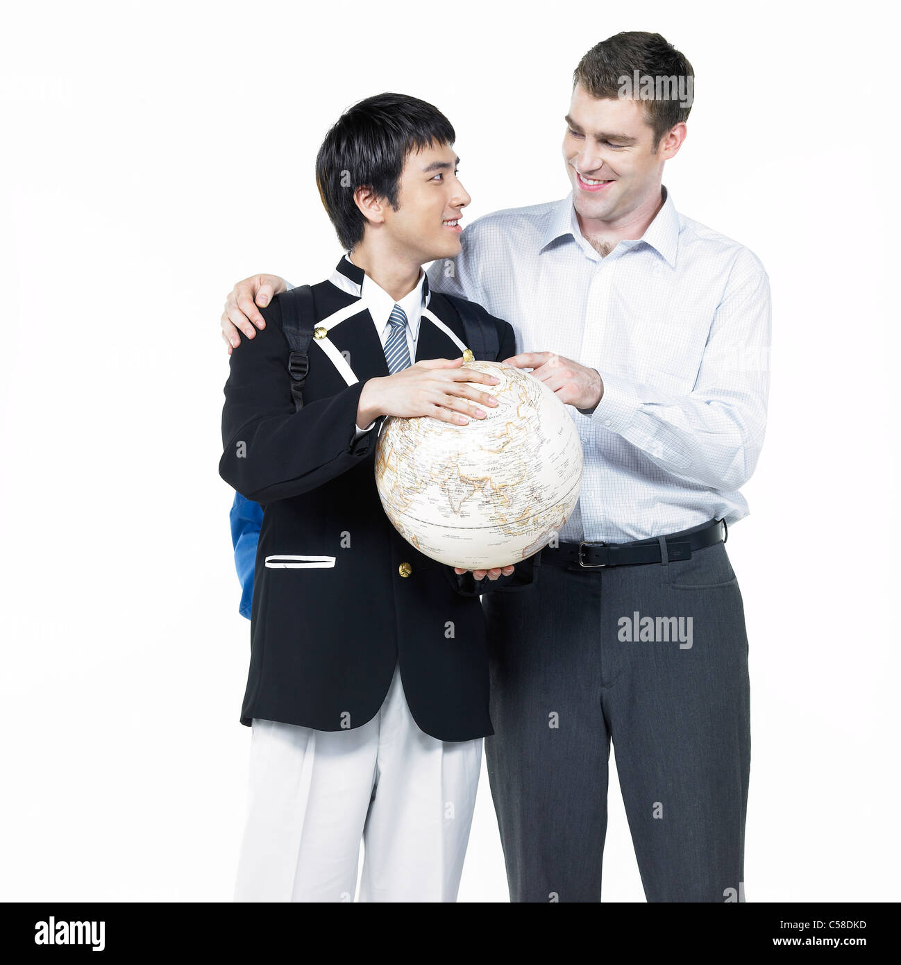 Close-up del ragazzo in piedi con insegnante, holding globe Foto Stock