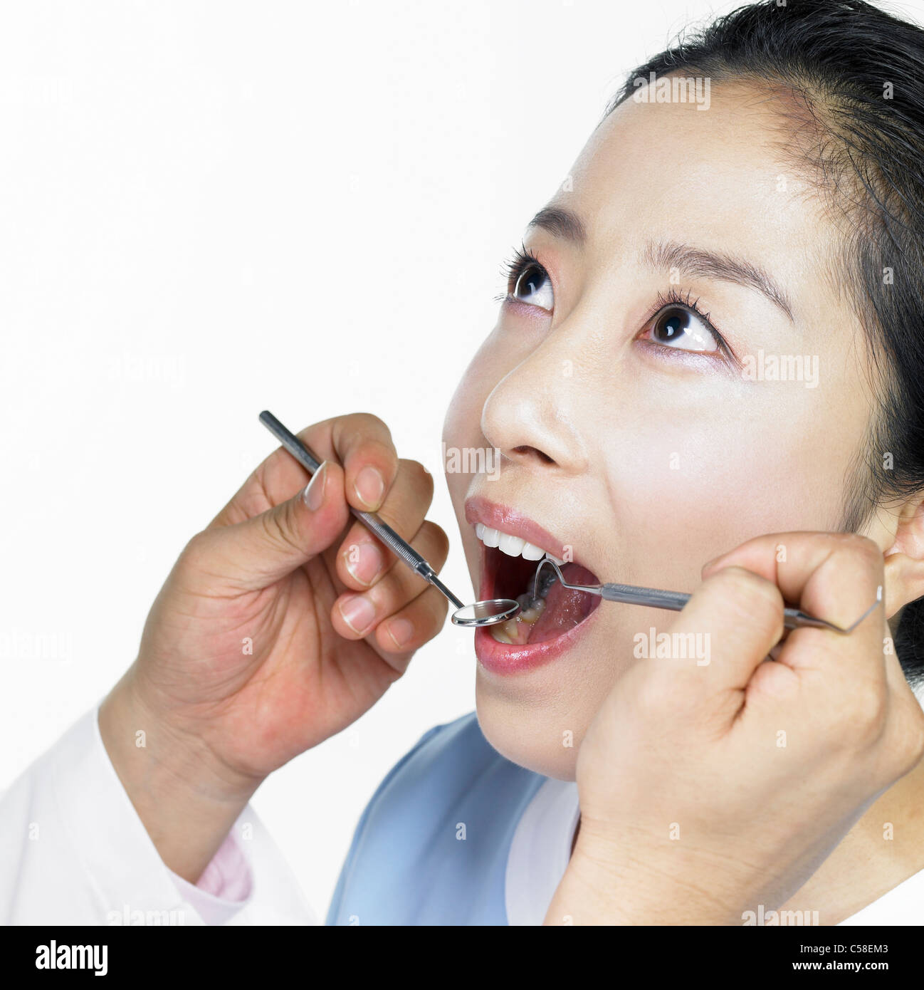 Dentista usando uno specchio su paziente Foto Stock