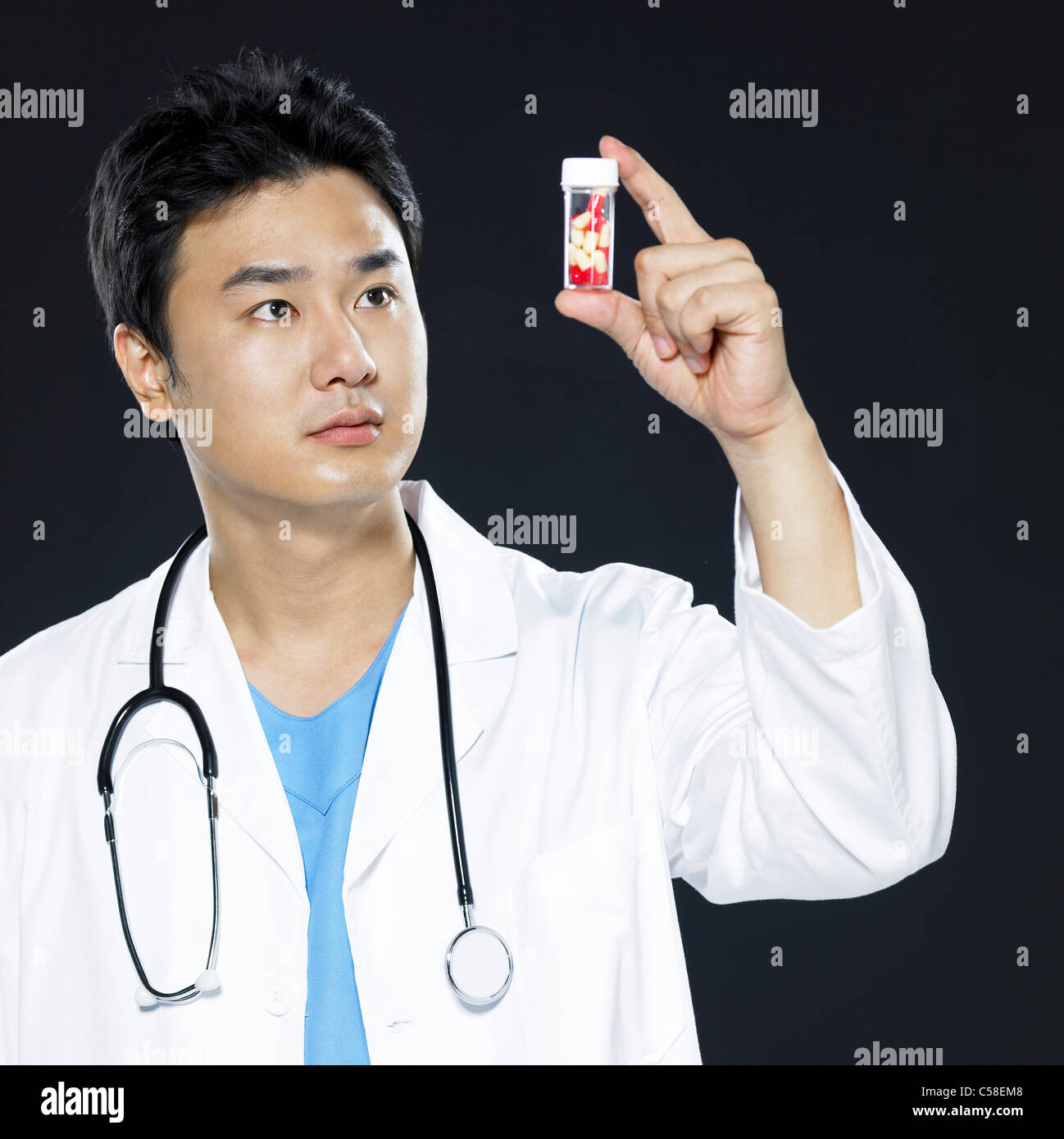 Medico maschio tenendo in mano una bottiglia di pillole Foto Stock