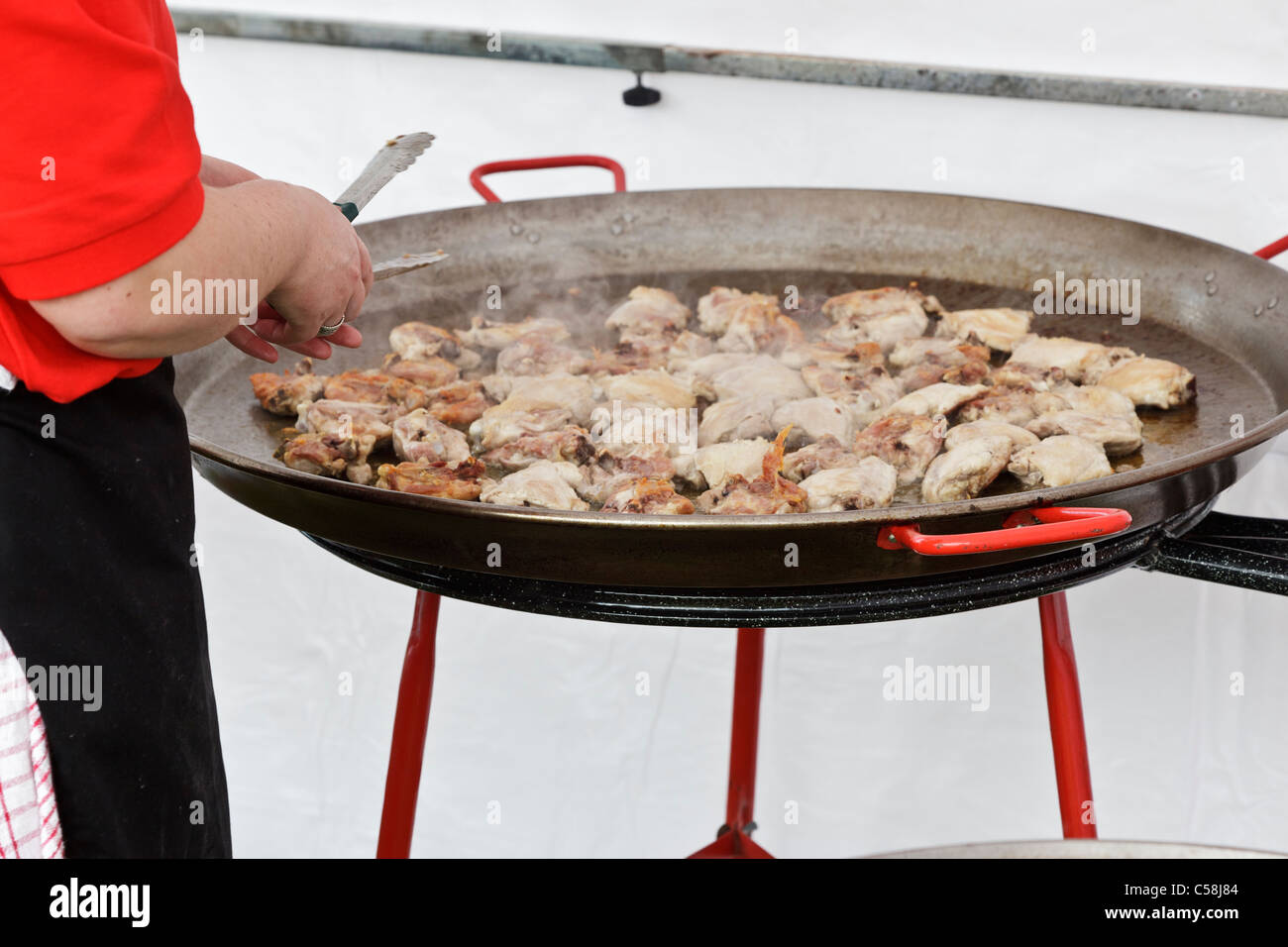 Outdoor catering di massa a un festival di musica - cottura di pollo per la paella Foto Stock