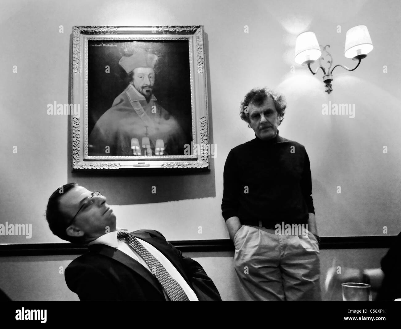 Due uomini uno in piedi l'altra seduta da un dipinto del Cardinale Richelieu a un matrimonio in Inghilterra Foto Stock