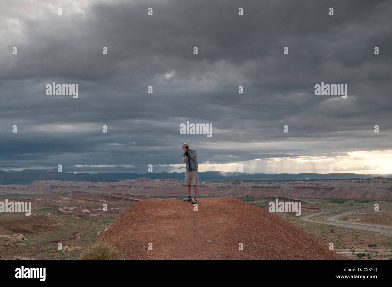 Un uomo prende una fotografia di fronte ad una tempesta nel deserto dello Utah lungo i-70 Foto Stock