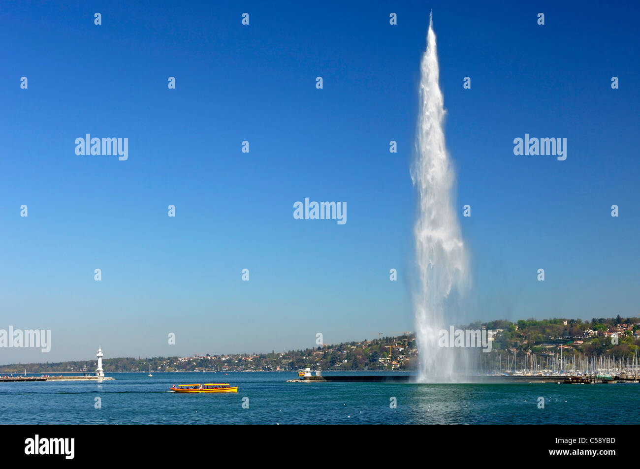 Un giallo ferry boat è passante il gigante fontana Jet d'Eau presso il porto di Rade bassin, sul Lago di Ginevra, Ginevra, Svizzera Foto Stock