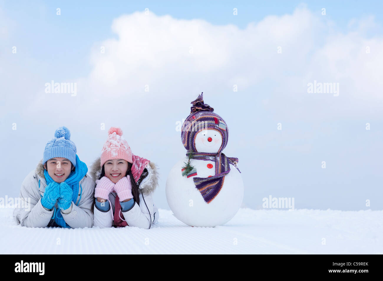 Giovane uomo e donna godendo sulla terra incappucciate di neve Foto Stock