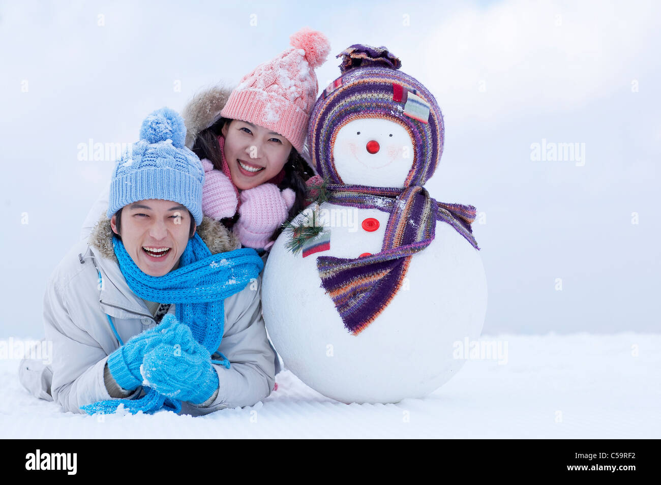 Giovane uomo e donna godendo sulla terra incappucciate di neve Foto Stock