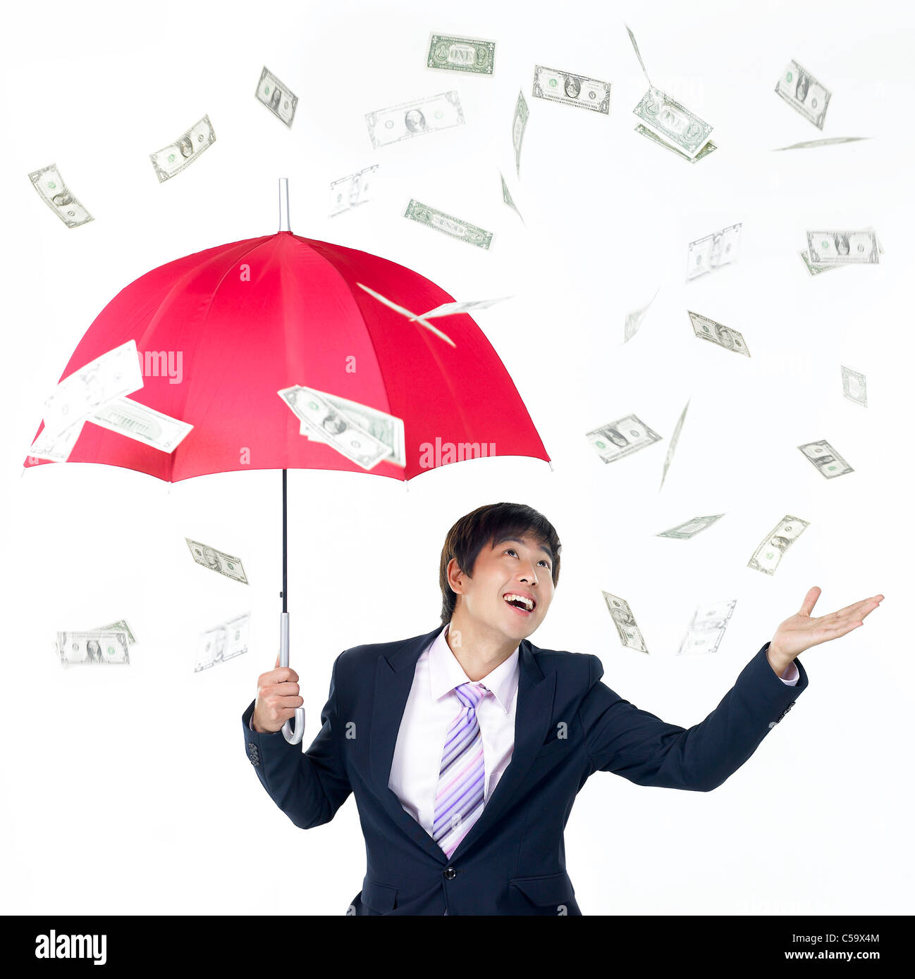 I soldi piovono a imprenditore sotto ombrellone Foto Stock