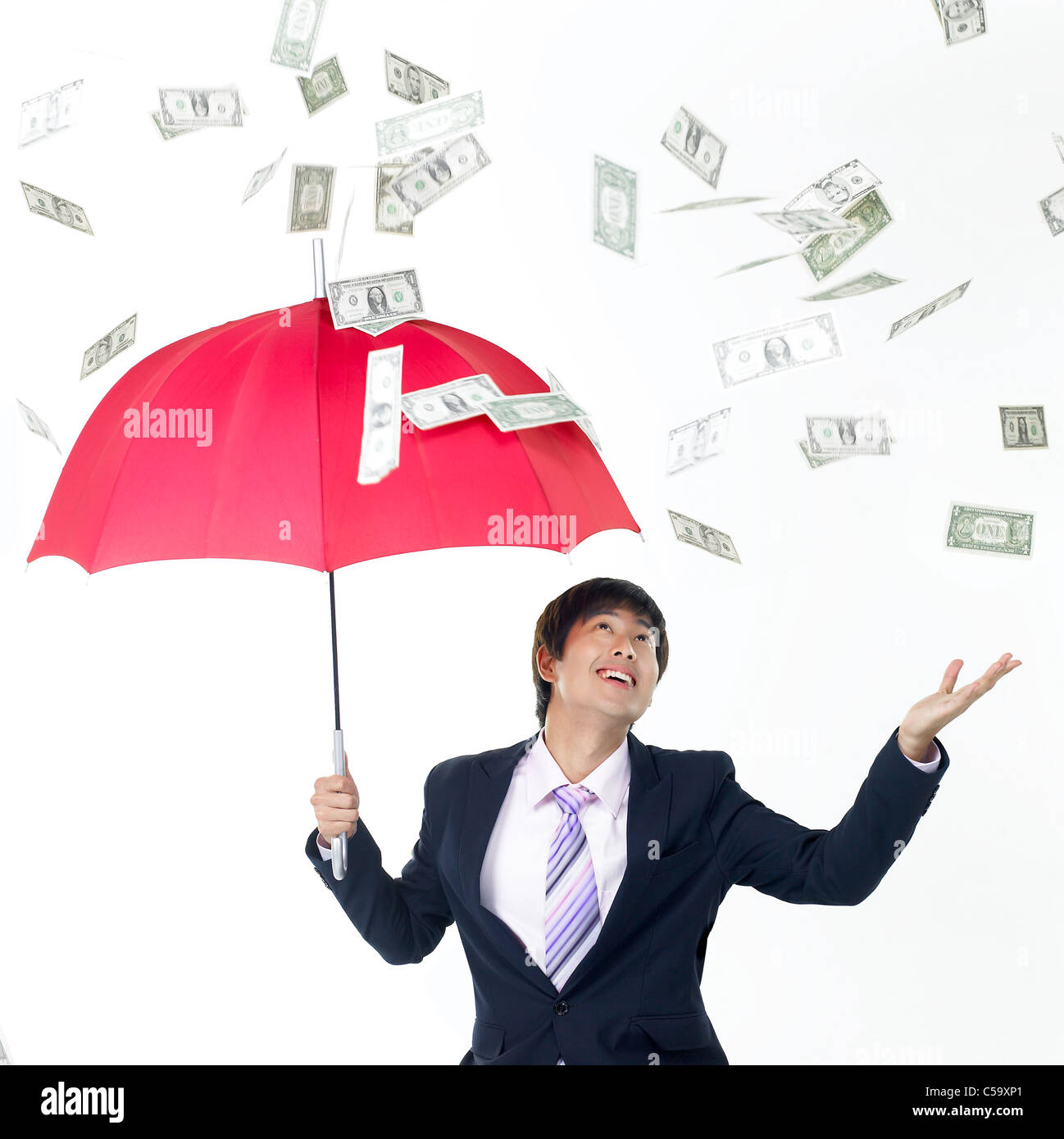 I soldi piovono a imprenditore sotto ombrellone Foto Stock