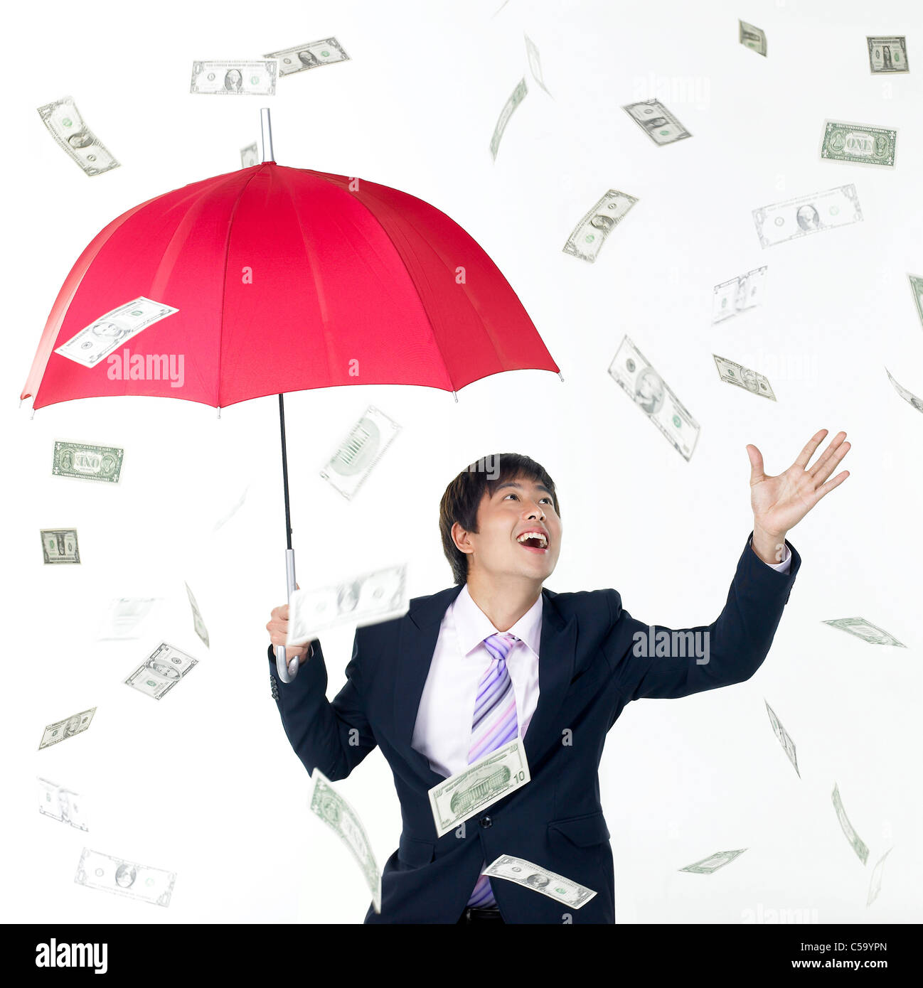 I soldi piovono a imprenditore sotto ombrellone Foto Stock