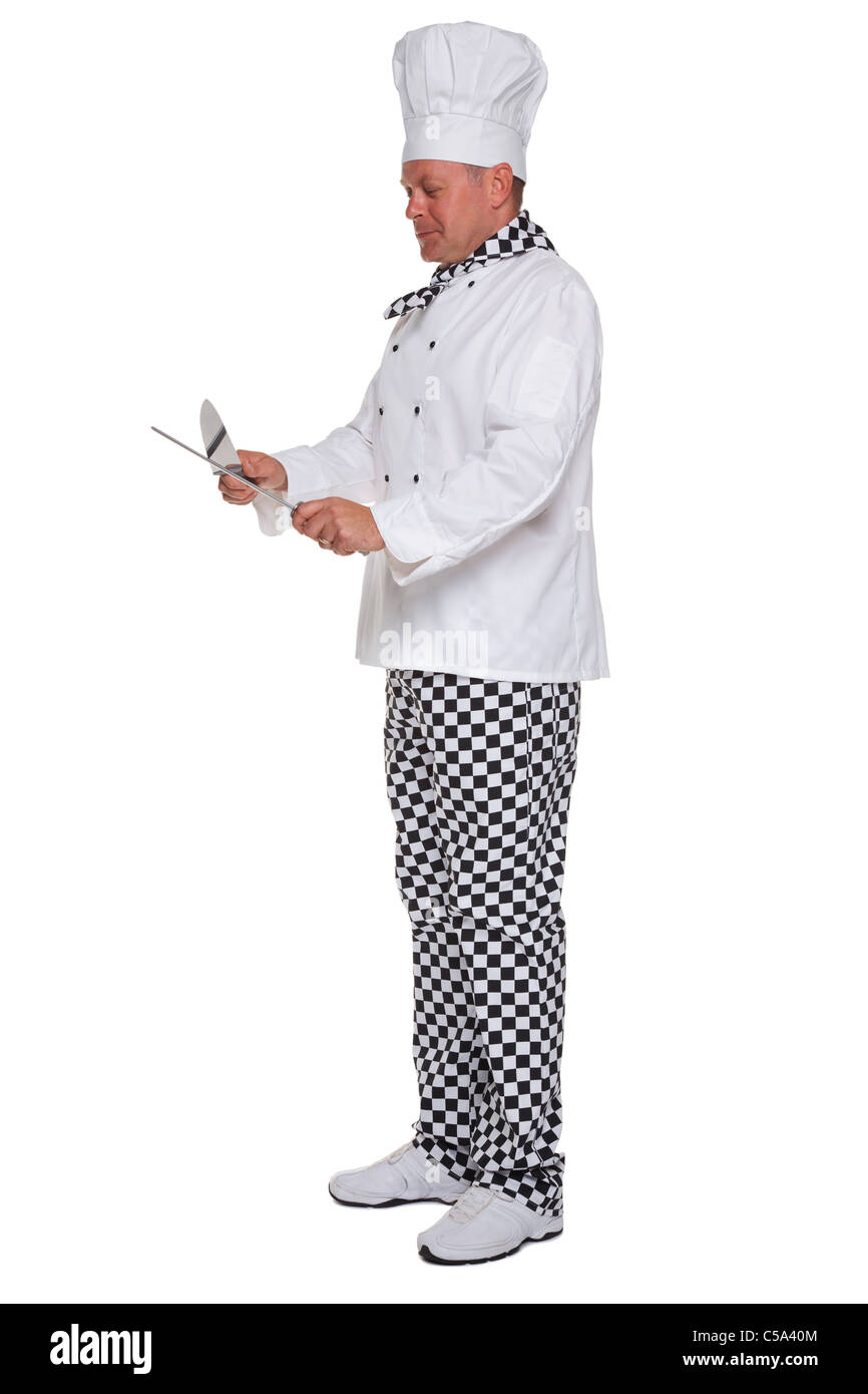 Foto di uno chef in bianco uniforme affilatura di un coltello isolato su uno sfondo bianco. Foto Stock