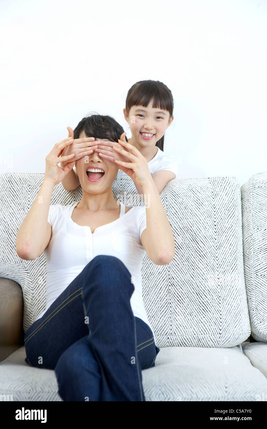 Ritratto della figlia tenendo le mani sulla madre agli occhi Foto Stock