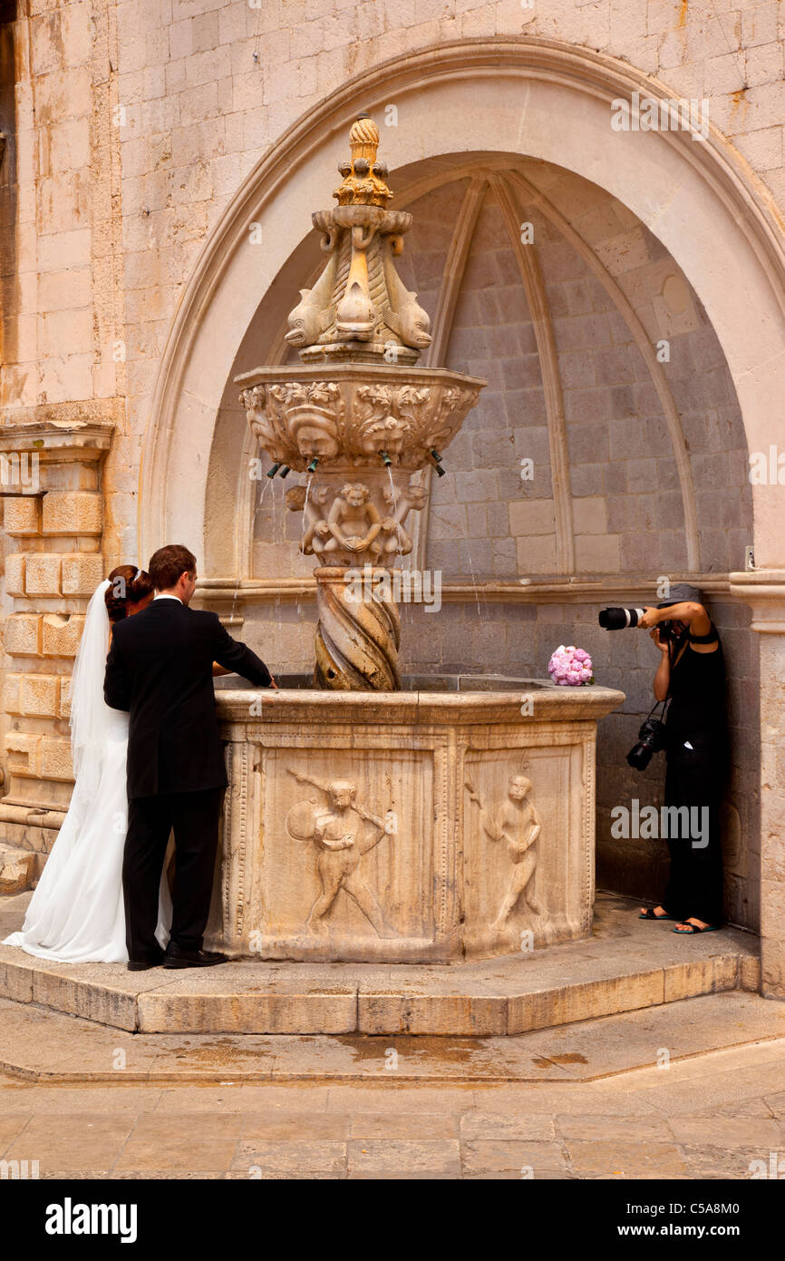 Sposa e lo Sposo che posano per una foto di nozze presso il piccolo Onofrio fontana di Dubrovnik, Dalmazia Croazia Foto Stock