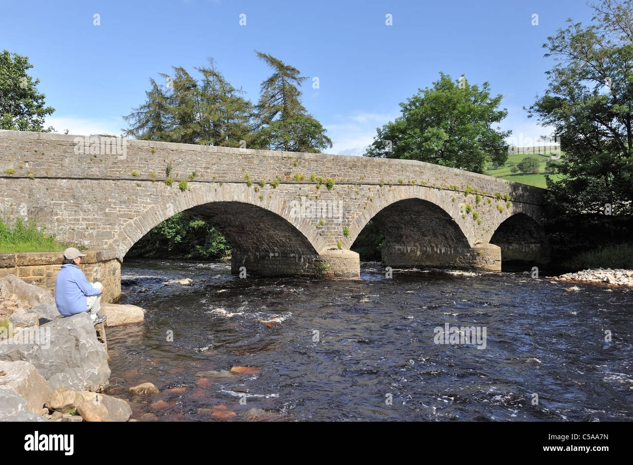 Appoggiata dal fiume impetuoso Swale, Isles Bridge, North Yorkshire, Inghilterra Foto Stock