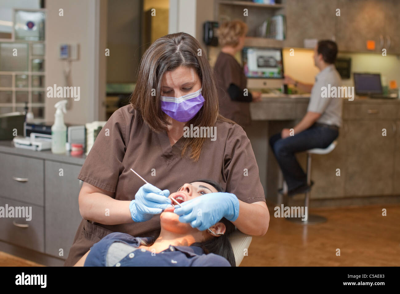 Femmina bianca assistente dentale recensioni denti della femmina paziente ispanica durante la visita a ortodontista Foto Stock