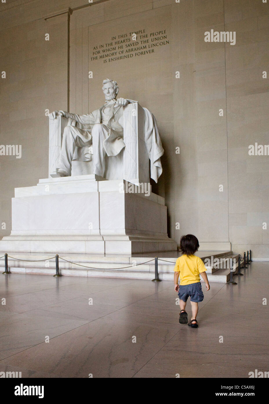 Un bambino piccolo che cammina verso la statua di Lincoln Foto Stock